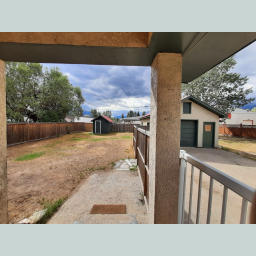 Fully fenced yard with storage sheds and garden areas